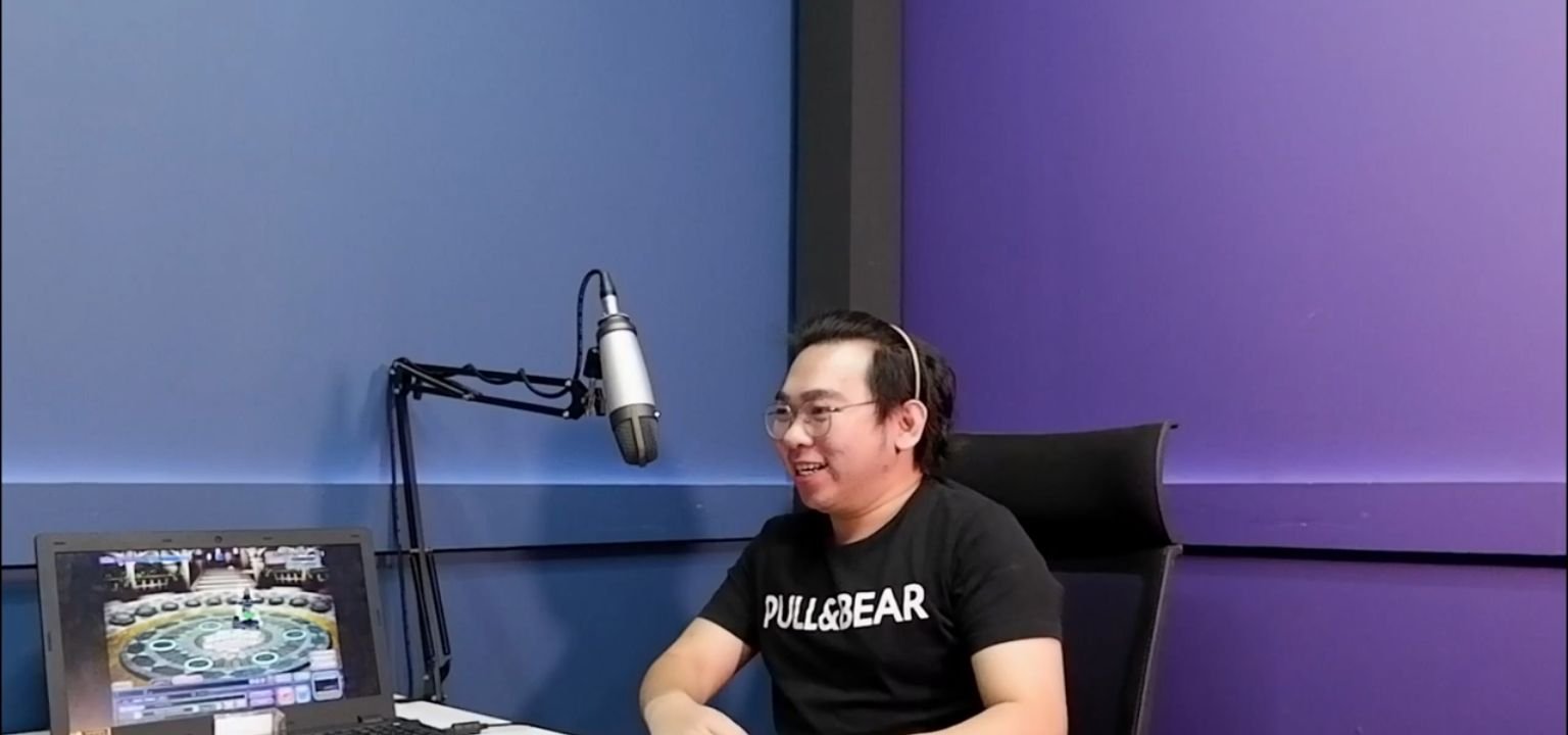 Host AyoShowcast di studio bersama mikrofon dan laptop